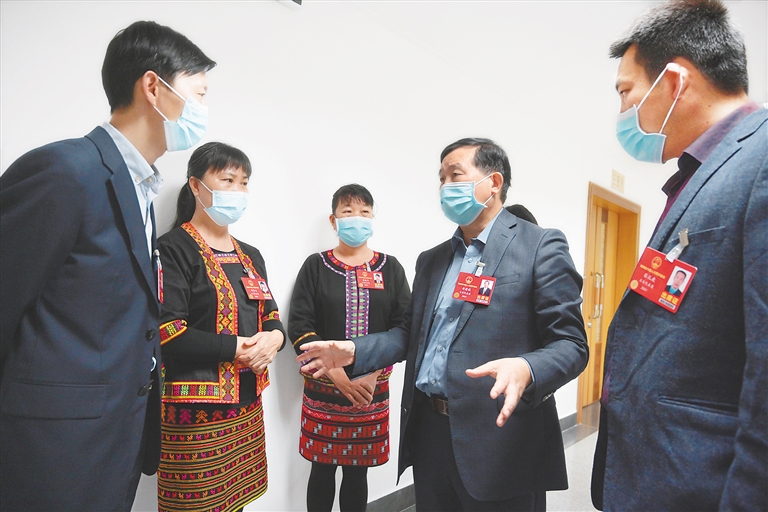 李健保代表和幾位基層代表在一起討論山區(qū)教育提質(zhì)的問題