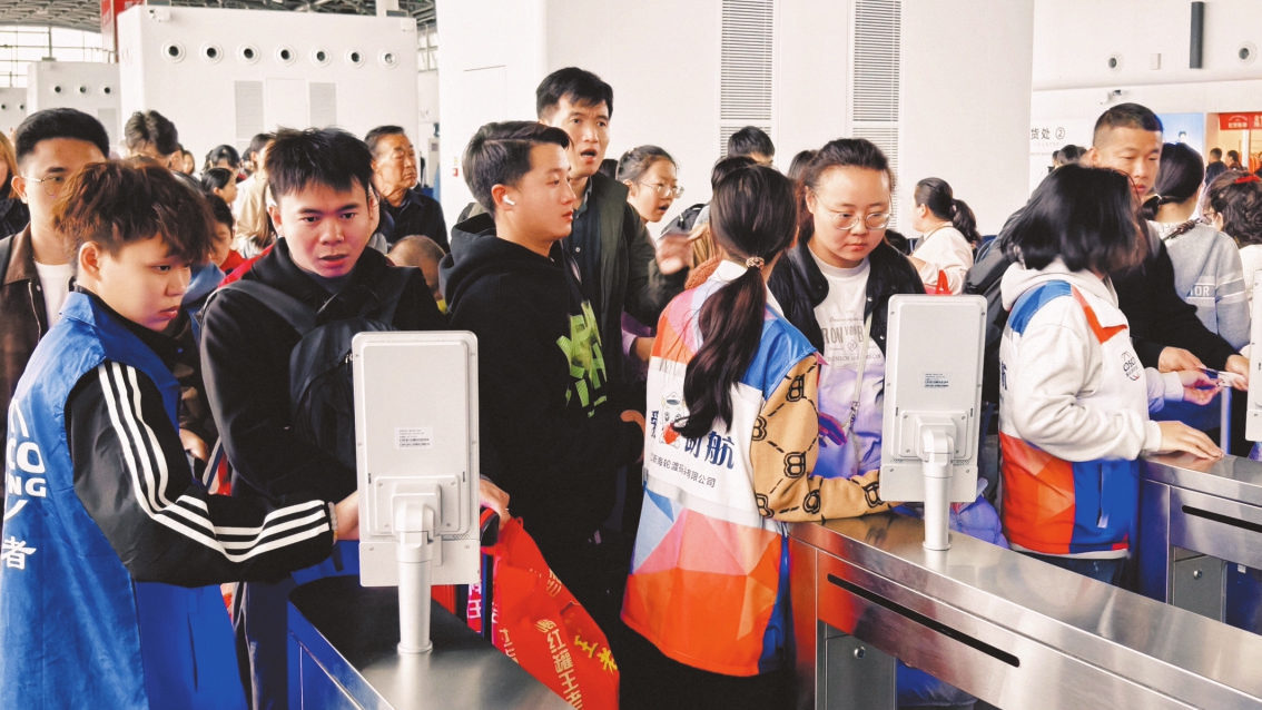 在海口新海港，志愿者協助過海旅客通過安檢口