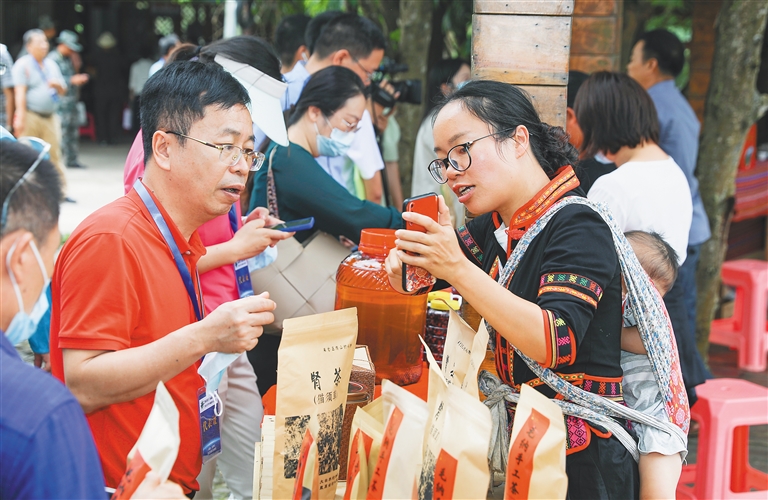 毛納村村民在向游客介紹當地的特色產品
